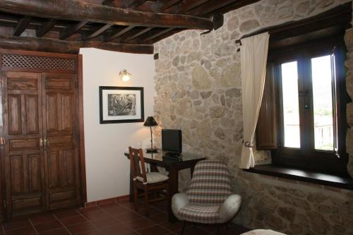 a room with a desk and a chair and a window at Posada Puerta Grande in Candelario