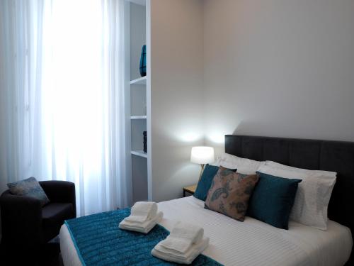 una camera da letto con un letto con due paia di scarpe sopra di Cool Terrace Apartment a Porto