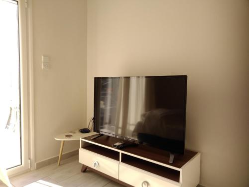 a flat screen tv sitting on a stand in a living room at Central Cozy Flat in Athens
