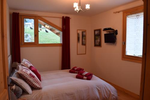 a bedroom with a bed with red pillows on it at Apartment La Tibolire in Sixt