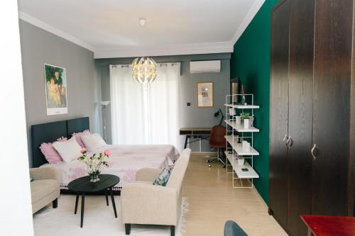 コモティニにあるCosy Downtown Studio - Suiteのベッドルーム1室(ベッド1台、ソファ、テーブル付)