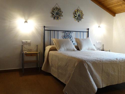 a bedroom with a large bed with two pillows at Alojamiento Rural El Lario in Alcalá de los Gazules