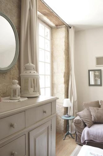 La salle de bains est pourvue d'une commode avec un miroir et un canapé. dans l'établissement La Forge - Historical Apartment Sarlat, à Sarlat-la-Canéda