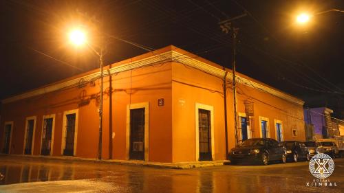 un edificio arancione su una strada di notte di Hostal Xiinbal a Mérida