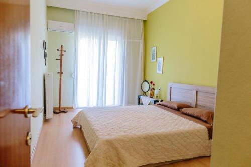 um quarto com uma cama grande e uma janela em Cosy Apartment in the Centre of Komotini em Komotini