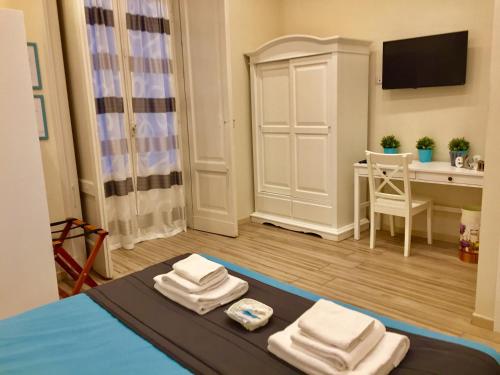 Una habitación con una cama y una mesa con toallas. en Da Polly a Piazza Amedeo en Nápoles