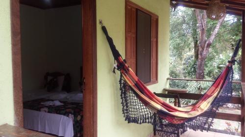 a hammock hanging on a wall next to a window at Pousada Licuri in Serra do Cipo