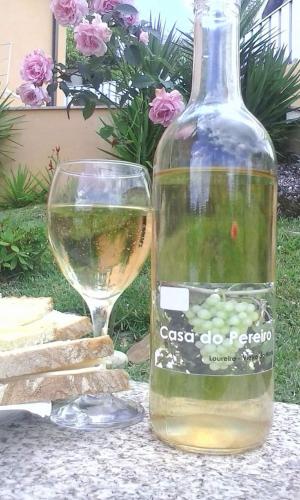 a bottle of wine sitting next to a glass at Casa do Pereiro in Vieira do Minho