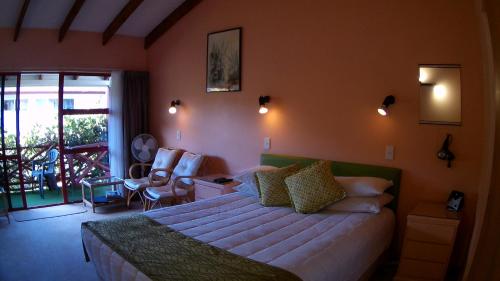 ein Hotelzimmer mit einem Bett und einem Balkon in der Unterkunft Alfa Boutique Motel in Paihia