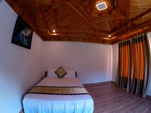 a bedroom with a bed and a wooden ceiling at Charm's Homestay in Phong Nha