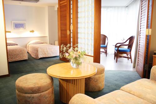 a hotel room with a table and two beds at Fuji Premium Resort in Fujikawaguchiko