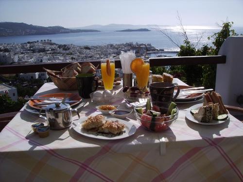 een tafel met eten en drinken op een tafel met uitzicht bij La Veranda of Mykonos Traditional Guesthouse in Mykonos-stad