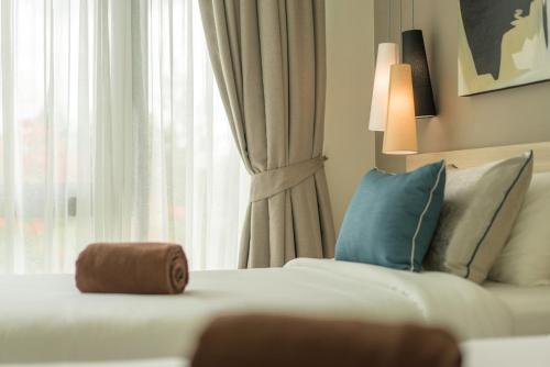 a hotel room with a couch and a window at Oceanstone by RESAVA in Bang Tao Beach