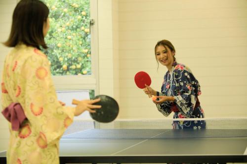 two women playing a game of ping pong at Atami Fuga in Atami