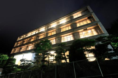 a lit up building with trees in front of it at Atami Fuga in Atami