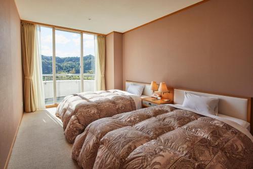 Łóżko lub łóżka w pokoju w obiekcie Kamogawa Country Hotel