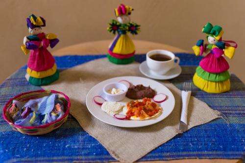 ein Tisch mit einem Teller Essen und einer Tasse Kaffee in der Unterkunft Berakah B&B- Central Park in Ruinas de Copán