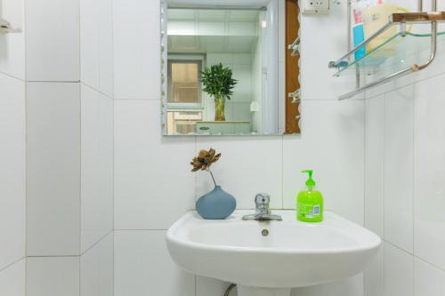 a white bathroom with a sink and a mirror at Jinan Shizhong·Quancheng Square· Locals Apartment 00127290 in Jinan