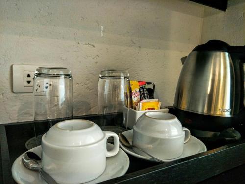 two white cups and saucers on a kitchen counter at Sugar Palm Grand Hillside - SHA Plus in Kata Beach