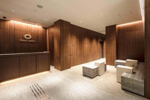 a lobby with wood paneling and a waiting room at Hotel Comfact in Tokyo