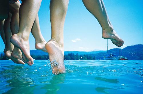 a group of four people standing in the water at Dei Hotel Schönblick in Velden am Wörthersee