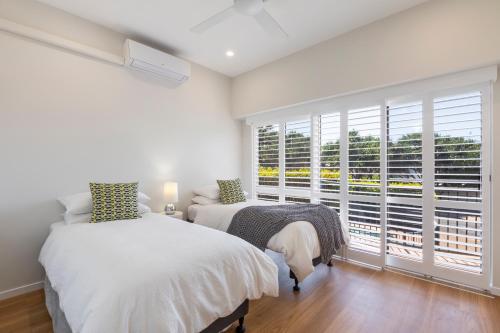 a bedroom with two beds and a large window at Location, location, Sunshine Beach in Sunshine Beach