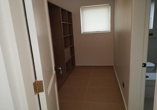 a small hallway with a door and a window at Pinares de Higuerillas in Maitencillo