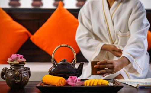 a woman in a hotel room with a tray of food at Sabara Angkor Resort & Spa in Siem Reap