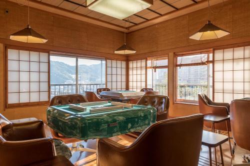a conference room with tables and chairs and windows at Atami Onsen Sakuraya Ryokan in Atami