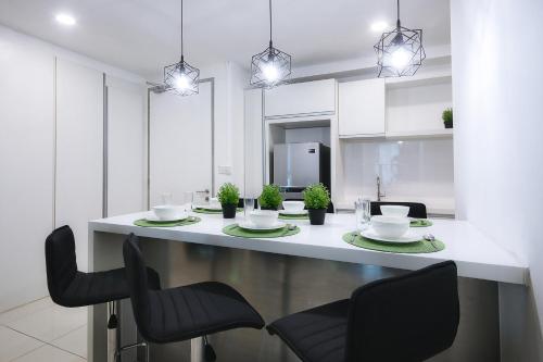 a white kitchen with a table and chairs at KEEN Suites@Sutera Avenue in Kota Kinabalu