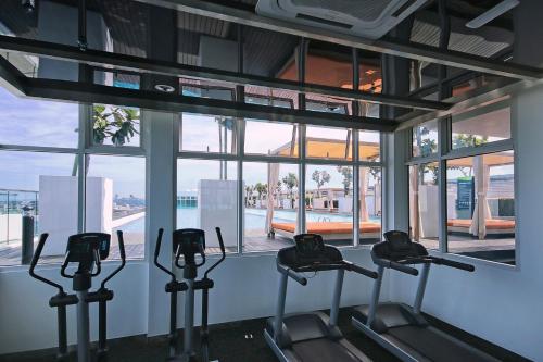 a group of treadmills in a gym with windows at KEEN Suites@Sutera Avenue in Kota Kinabalu