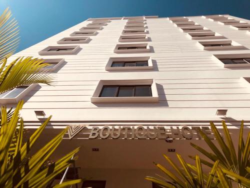 a tall white building with a sign on it at V Boutique Hotel in Phnom Penh
