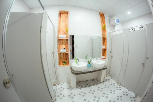 La salle de bains est pourvue de 2 lavabos et d'un miroir. dans l'établissement Rubis Hostel, à Hue