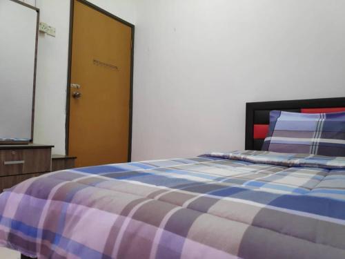 a bedroom with a blue and purple bed and a door at Homestay PD in Port Dickson