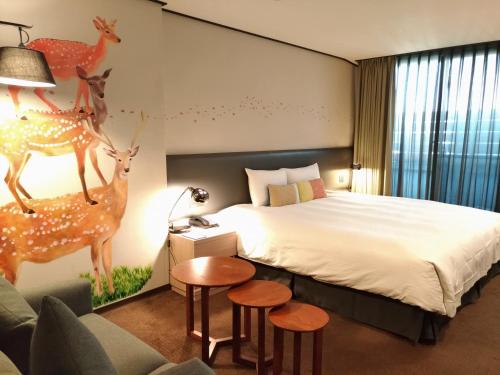 a hotel room with a large bed and some animals on the wall at Energy Inn in Taipei