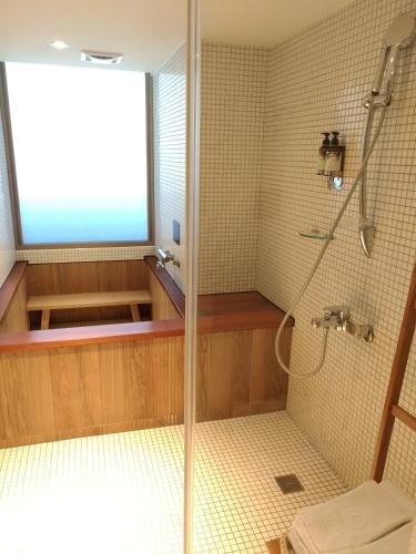 a shower with a glass door in a bathroom at Energy Inn in Taipei