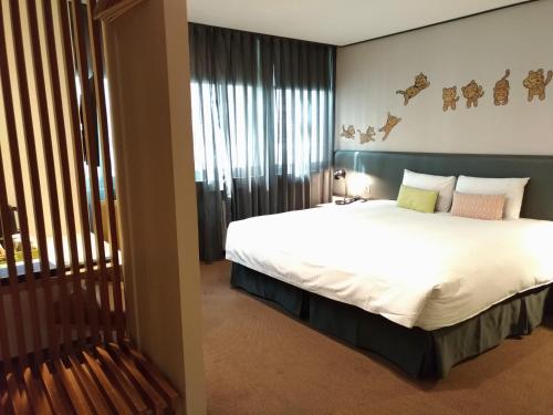 
a bedroom with a large bed and a large window at Energy Inn in Taipei
