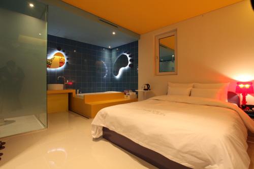 a bedroom with a bed and a bathroom with a tub at Hotel POP3 Jongno in Seoul
