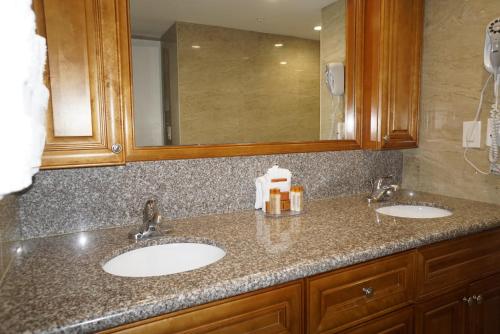 a bathroom with two sinks and a mirror at Ocean Sky Hotel & Resort in Fort Lauderdale