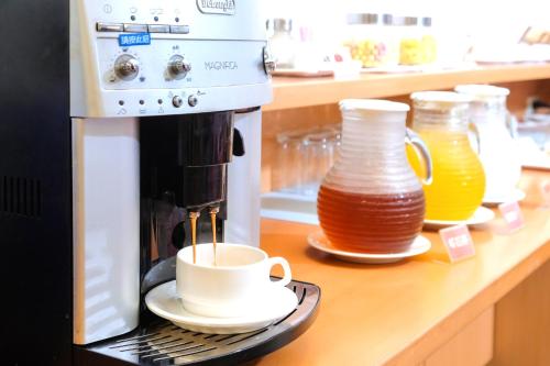 a coffee machine sitting on a counter with a cup of coffee at Natoli Motel in Tainan