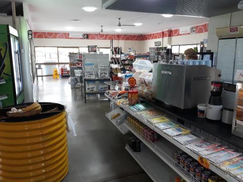 a grocery store aisle with a woman standing at the counter at Speewah Country Tavern in Speewah