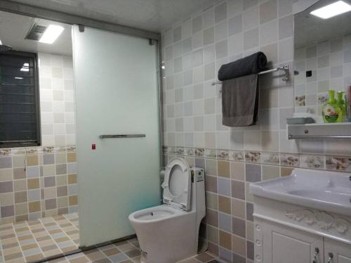 y baño con aseo y lavamanos. en Henan Luoyang·Wangfujing Department Store· Locals Apartment 00129770 en Luoyang