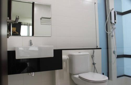 een badkamer met een toilet, een wastafel en een spiegel bij 2-Bedroom Apartment@Trefoil Setia Alam in Shah Alam