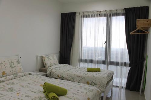 een slaapkamer met 2 bedden en een raam bij 2-Bedroom Apartment@Trefoil Setia Alam in Shah Alam