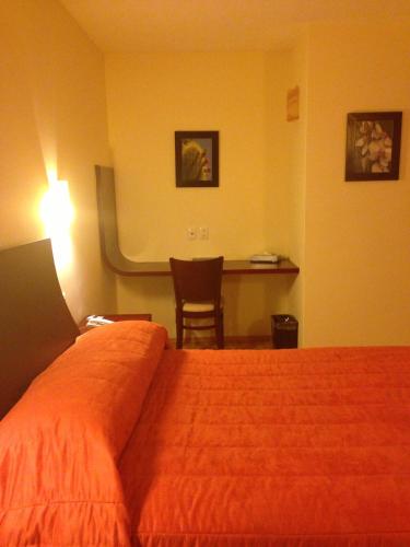 a hotel room with a bed and a desk at Hotel CR Tehuacan in Tehuacán