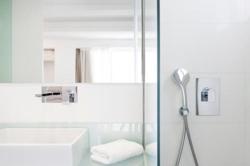 une douche avec une porte en verre à côté d'un lavabo dans l'établissement Artrip Hotel, à Madrid