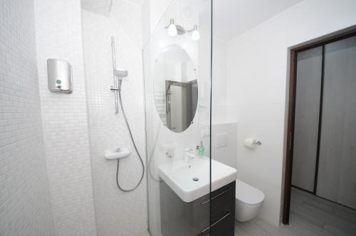 un bagno bianco con lavandino e specchio di Apartament Panoramic a Galaţi