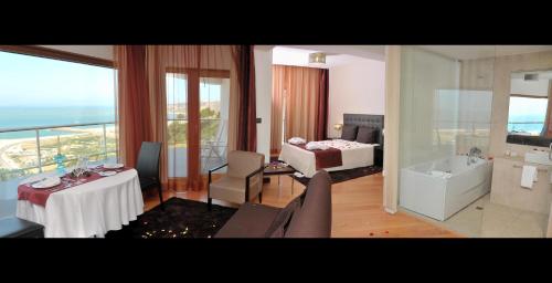 een woonkamer met een kamer met een bed en een badkamer bij Hotel Miramar Sul in Nazaré