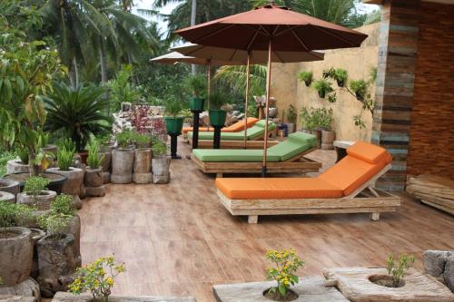 a patio with two chairs and an umbrella at AgaLiving Medewi in Pulukan