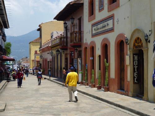 a man walking down a street in a town at Hotel San Martin in San Cristóbal de Las Casas